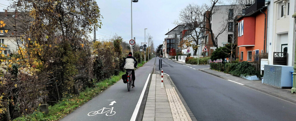 Ein Mann fährt auf einem linksseitig geführten Radweg